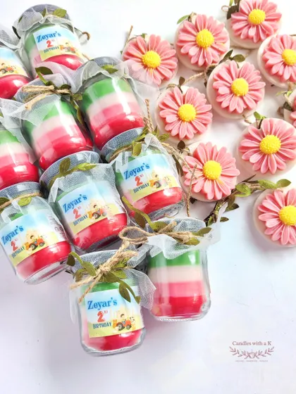 The components of the farm-themed gift set: personalized layered candles and pink daisy wax sachets, ready for assembly.
