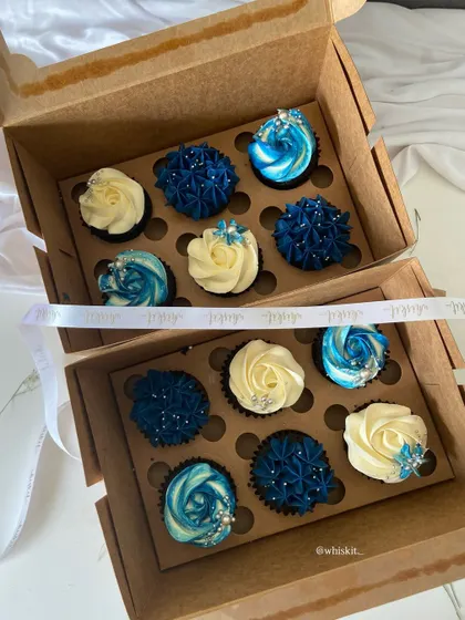Another view of the blue and white cupcake assortment, tied with a branded ribbon for a polished gifting experience.