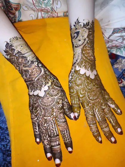 A beautiful example of bridal henna with contrasting light and dark shading, creating depth in the peacock and floral motifs.