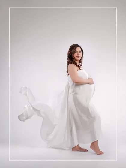 A minimalist and ethereal portrait using a simple white drape. The movement in the fabric adds a touch of artistic flair to this beautiful solo shot.