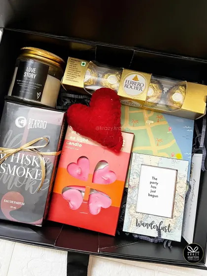 A birthday hamper for him, featuring 'Whisky Smoke' perfume, a 'Love Story' candle, heart-shaped tea lights, and Ferrero Rocher.