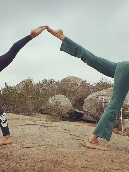 The same partner pose from a slightly different angle, highlighting the strength and balance required. It's a playful and challenging way to practice together.