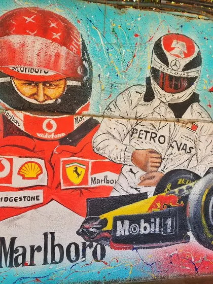 A tribute to Formula 1 legends Michael Schumacher and Lewis Hamilton, painted in a gritty, colorful street art style at Burnout Café.