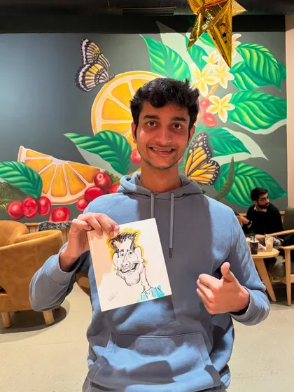 This young man gives a thumbs up for his caricature, a fun surprise during his coffee break.