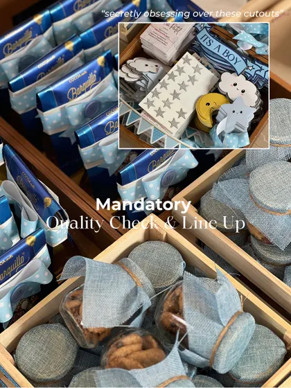 A mandatory quality check before anything goes out. I'm inspecting the treats and the custom celestial-themed cutouts for the 'It's a Boy' announcement hampers.
