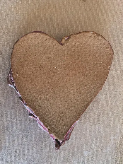 The bottom of the heart-shaped dish, showing the raw, unglazed terracotta clay. This contrast between the glossy top and earthy base is something I love to explore.