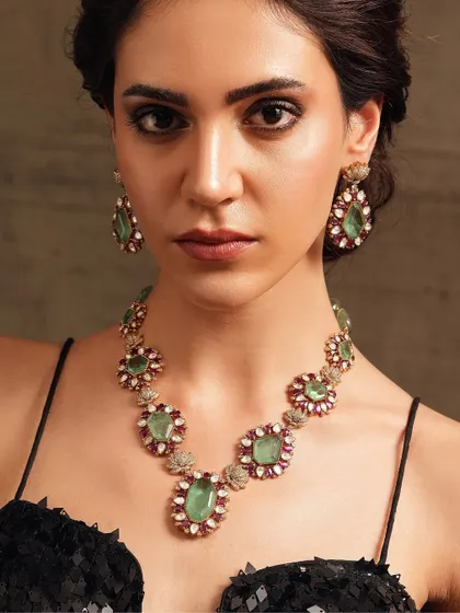 A statement necklace set with pastel green and pink stones, offering a softer, more romantic color palette.