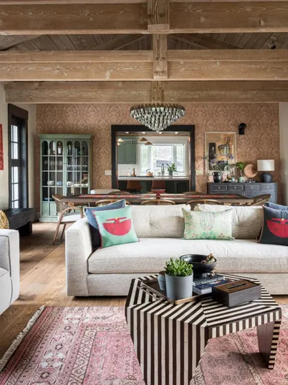 Another view of the Saratoga living room, showing how the striped coffee table and colorful cushions add a playful, modern touch to the otherwise rustic and elegant space.