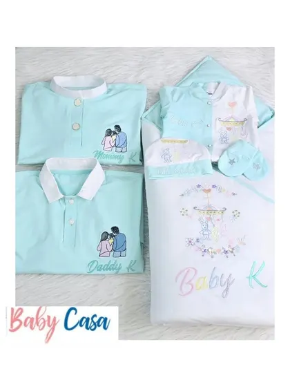 A closer look at the custom family set. The detailed embroidery of the parents on their shirts and the baby's coordinated outfit makes for a unique and heartwarming homecoming theme.