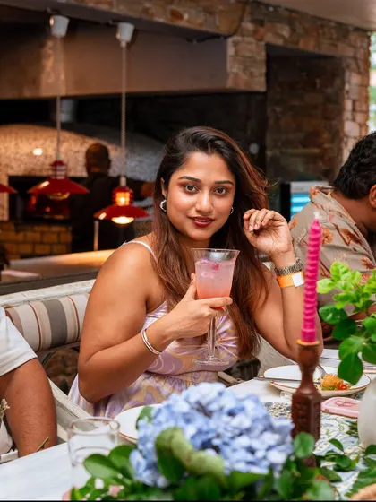 A guest enjoys a cocktail at her table, surrounded by the beautiful decor of my mansion. Our special Sunday event was an afternoon soaked in celebration, food, and stories.