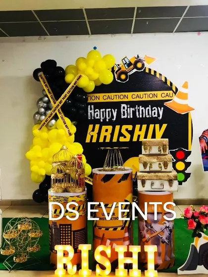 For the little one who loves trucks and tractors, this construction-themed party is perfect. The setup includes a custom backdrop, yellow and black balloon decor, a large marquee number "3", and themed props like a toy bulldozer.