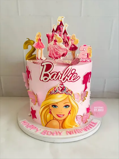 A dreamy Barbie cake with a castle topper and beautiful butterfly accents.