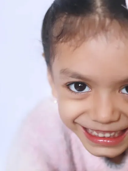 An infectious, wide-eyed smile that lights up the frame. This close-up portrait is all about capturing that pure, unfiltered happiness that is so unique to childhood.