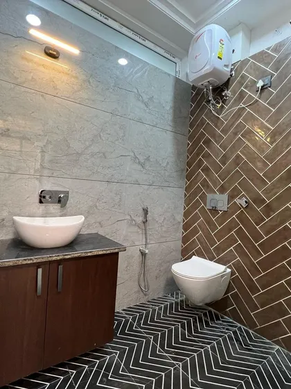 I love creating contrast with tiles. In this bathroom, the warm, wood-look herringbone tiles in the shower area stand out against the cool grey wall tiles and the bold black-and-white chevron floor.