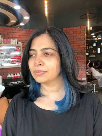 This client is rocking her new blue peek-a-boo highlights with confidence. It's a look that adds drama and personality.