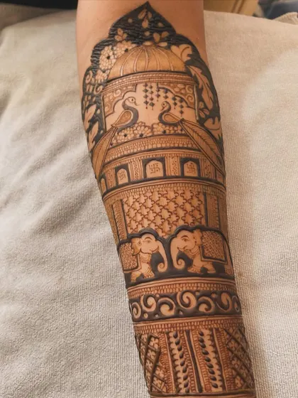 A full forearm piece depicting a royal scene. It includes elephants, peacocks, and a grand palace dome, creating a majestic and story-driven design.