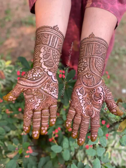 A full-coverage mehendi design with a mix of traditional patterns. The design is set against a natural backdrop, highlighting the beauty of the henna.