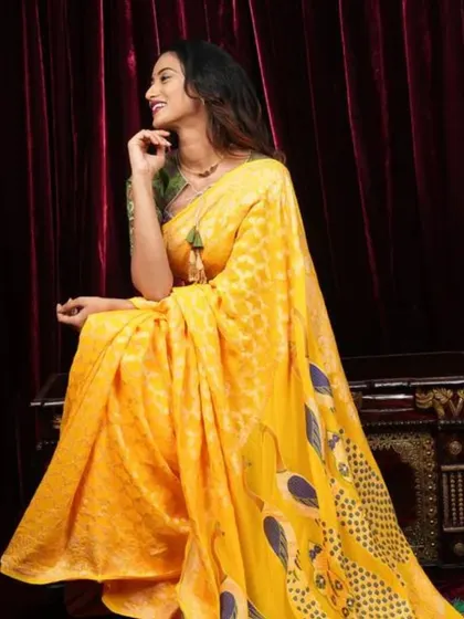 A bright and sunny yellow georgette saree with peacock feather prints on the pallu. This is a cheerful and stylish piece for any daytime event.