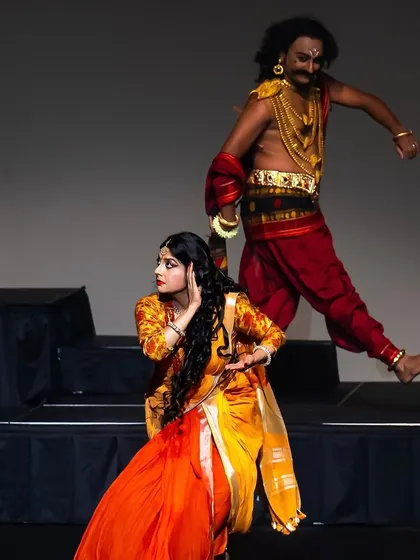 This dynamic pose captures the energy and drama of a chase scene in one of our mythological productions. The choreography combines athletic leaps with expressive storytelling to create a visually exciting performance.