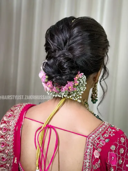 I created this soft, romantic low bun using fresh pink carnations and baby's breath. The loose tendrils frame the face beautifully, making it an ideal choice for a daytime wedding or engagement ceremony.