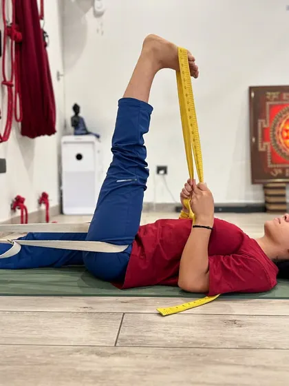 This is Supta Padangusthasana, or Reclining Hand-to-Big-Toe Pose, using a belt. The belt provides traction, allowing for a gentle yet deep hamstring stretch while keeping the spine neutral and relaxed on the floor.