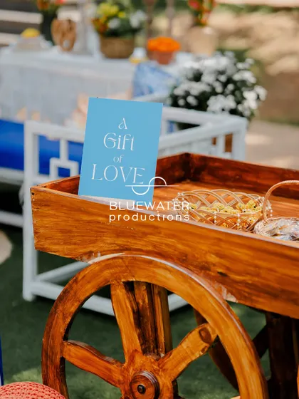 A small wooden cart holds gifts for guests, with a simple sign that reads "A Gift of Love."