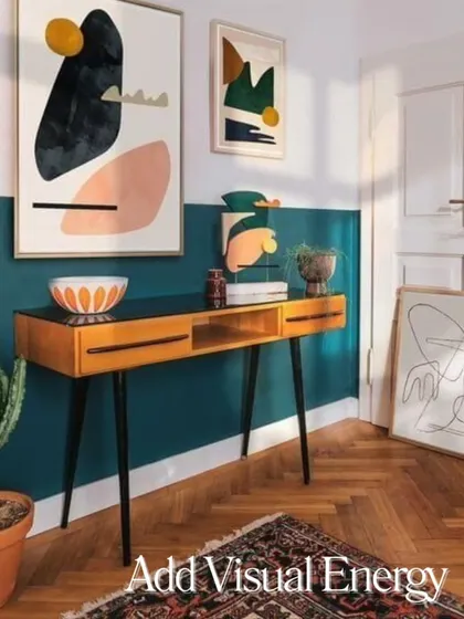 An example of how color blocking can add visual energy to a room, using a bold teal half-wall to create a dynamic and modern look.