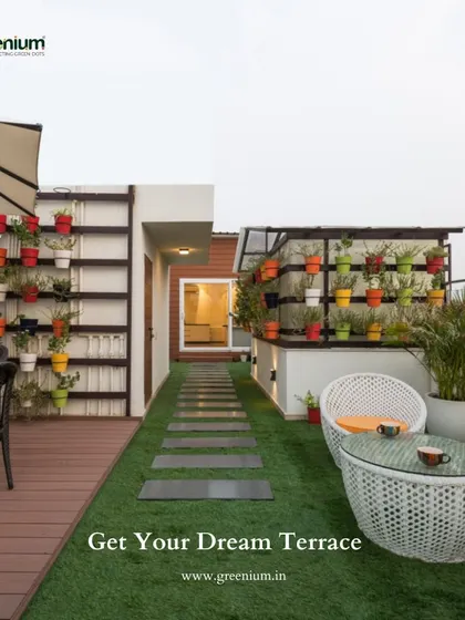 Let me help you get your dream terrace. This image showcases a complete terrace makeover with artificial grass, a wooden deck pathway, comfortable seating, and colorful vertical planters.