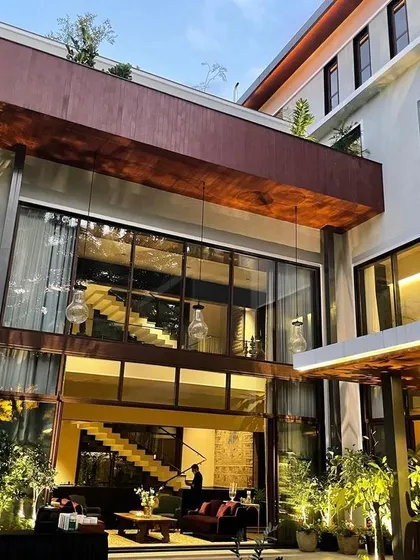 An alternate angle of the Koramangala residence, detailing the floating staircase visible through the expansive glass facade. This architectural feature serves as a central design element, adding visual interest and a sense of openness.
