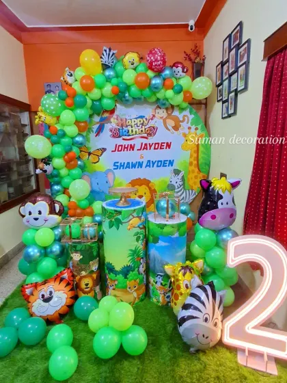 This photo shows the jungle party setup with the addition of a large, light-up marquee number '2'.
