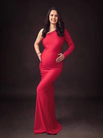 A classic full-length pose in a vibrant red gown. This is a timeless way to capture the beauty and strength of pregnancy.