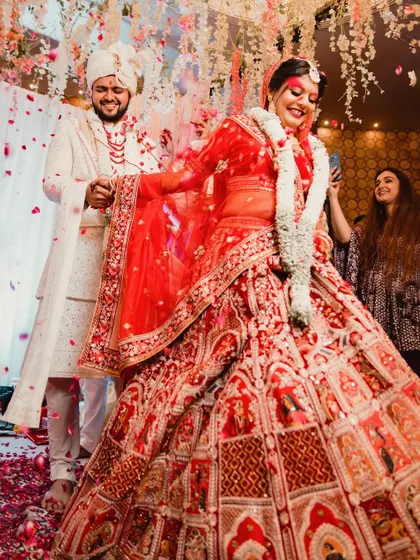 A candid shot of the bride's twirl during the wedding ceremony, with petals flying around her. This action shot captures the joy and celebratory atmosphere of the moment.