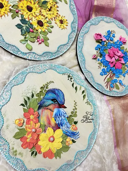 This is a set of three coordinated wall plates. I used a common color palette and border style to unite the different designs: one with sunflowers, one with a bird, and one with a pink and blue bouquet.