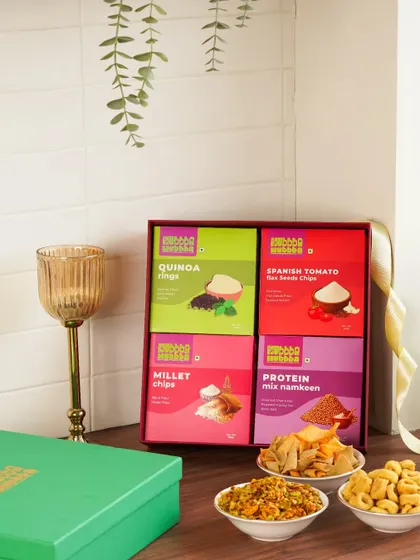 A colorful gift box of assorted healthy snacks, styled with a goblet to give it a premium, celebratory look.