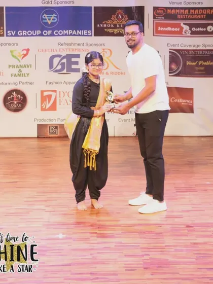 A young performer receiving her trophy at the "It's Time to Shine" showcase.