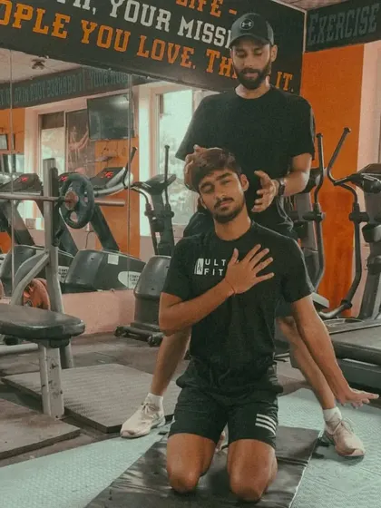 An athlete performs a guided stretch for the neck and upper back. These targeted movements are crucial for athletes, especially bowlers and batsmen who experience high rotational forces.
