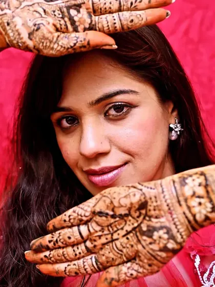 A close-up of the bride's hands, showing the detail and the beautiful, rich color of the henna.