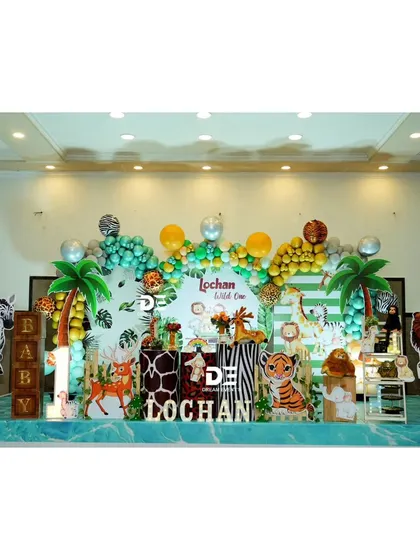A wider view of Lochan's jungle safari party, showing the full extent of the backdrop and the fun animal props, including large zebra and lion cutouts.