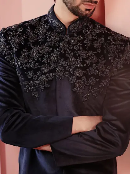 A close-up on the shoulder embroidery of the navy velvet jacket. The tonal threadwork creates a subtle yet stunning floral pattern.