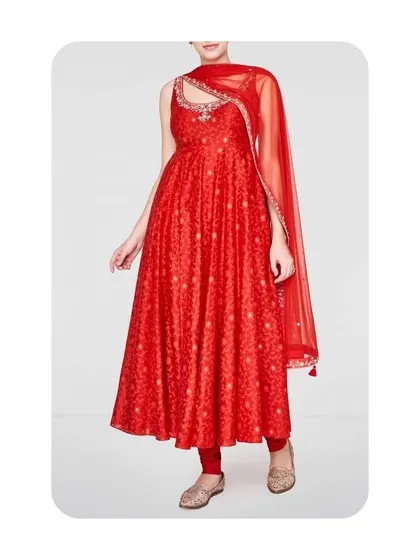 A vibrant red Anarkali suit with a unique cut-out neckline design. This is a great example of how I can incorporate modern tailoring details into a traditional outfit for a distinctive look.