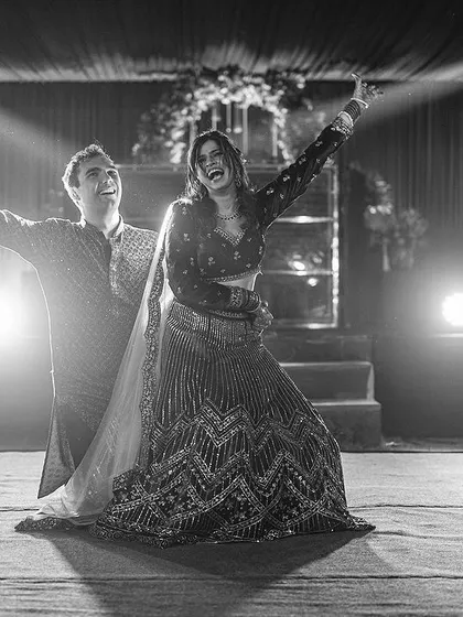 A joyful, high-energy moment from the couple's Sangeet performance, captured in timeless black and white.