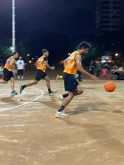 A fast break in progress. A player dribbles down the court, looking to create a scoring opportunity for his team.