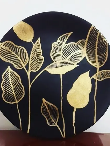 This circular wall art features a minimalist botanical design in gold leaf. It's a perfect example of how gold foil can be used to create modern and elegant home decor.
