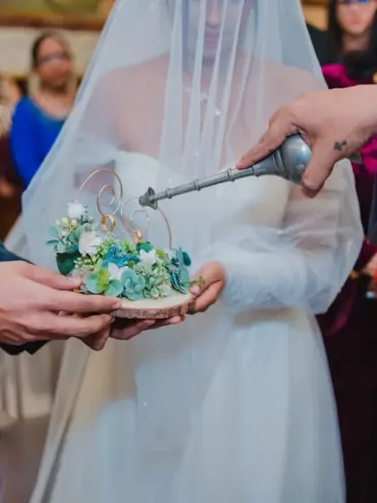 The blessing of the wedding rings, a close-up shot of a sacred ritual before the couple exchanges them.