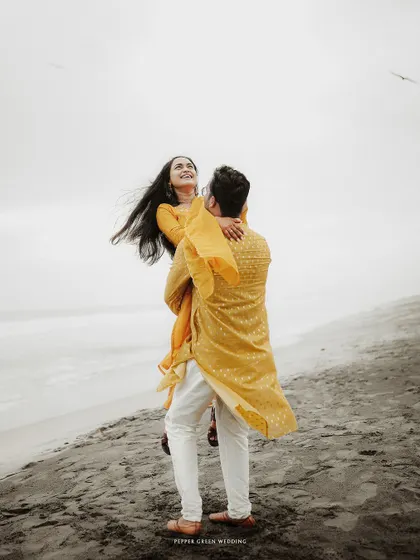A romantic lift on the beach, this pre-wedding photo is full of joy and a sense of carefree love.
