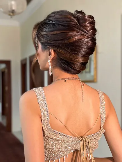 The back view of a sophisticated, voluminous updo. I created this style with interwoven sections to give it a modern texture while maintaining a classic bun shape.