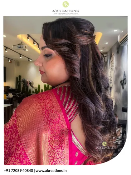 This side profile highlights a classic voluminous hairstyle with soft curls, designed to add a touch of glamour to a traditional saree look.