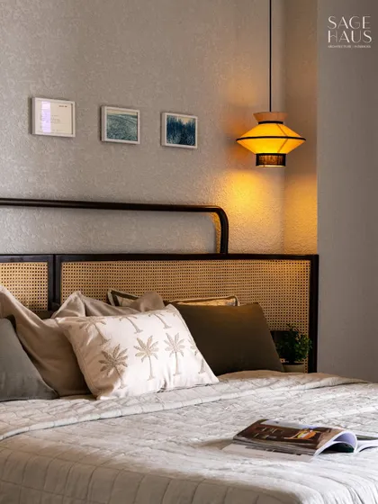 A closer look at the layered textures in this bedroom. The palm-print cushion adds a subtle tropical touch, while the open book invites you to unwind.