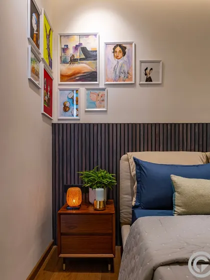 We believe in creating spaces for personal expression, like this art nook above the bed's headboard. The gallery wall allows the homeowner to display personal paintings, making the space uniquely their own.