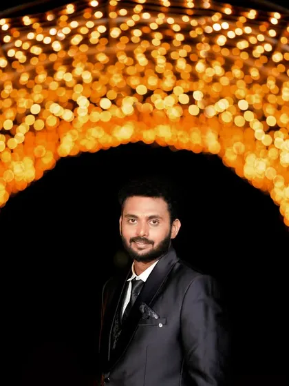 A creative groom portrait, framed by a tunnel of golden bokeh lights that draw all the focus to him.